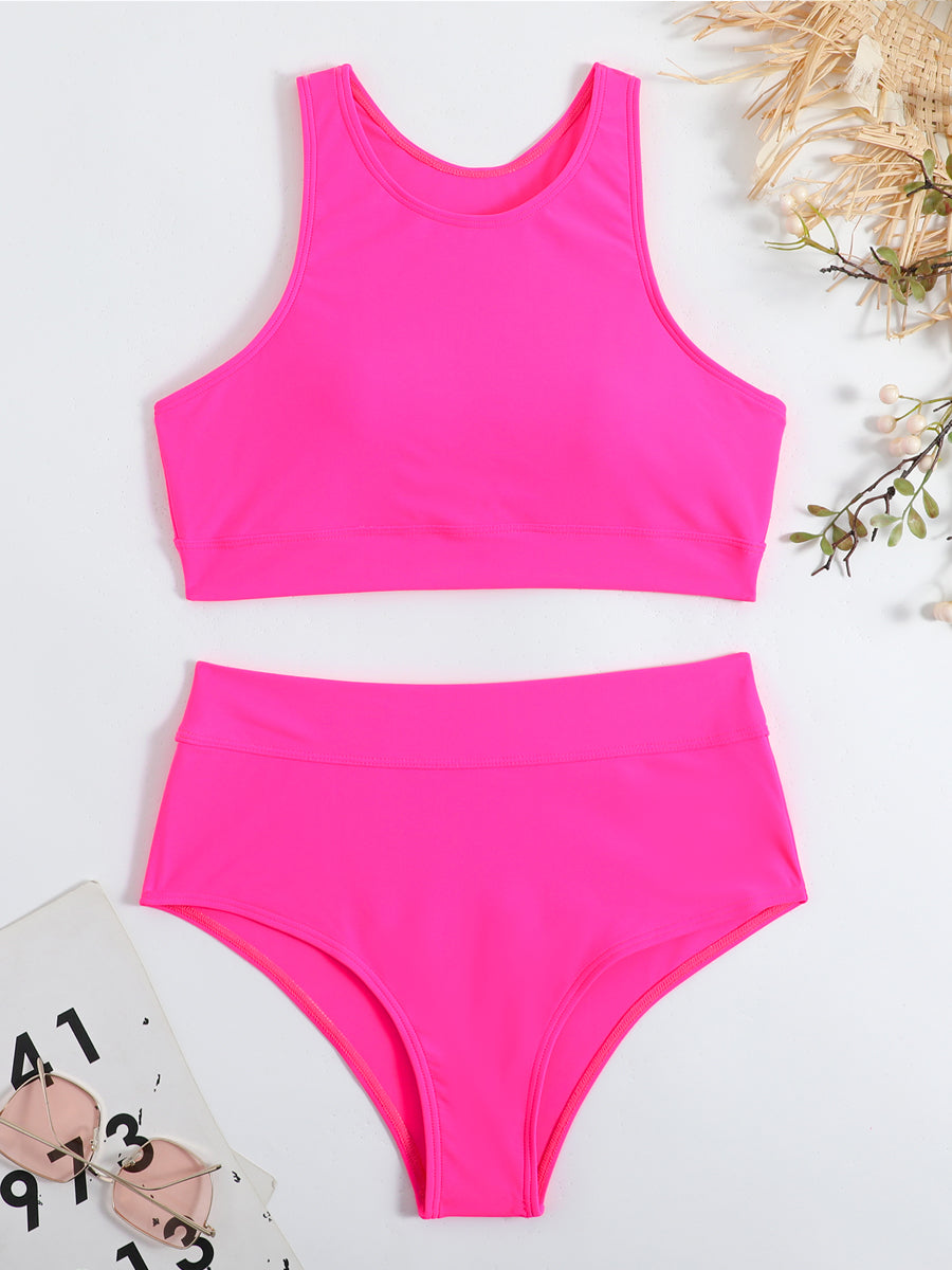 Bikini sportivo rosa fluo a due pezzi, top a canotta e slip a vita alta, su sfondo bianco con occhiali da sole e accessori estivi.