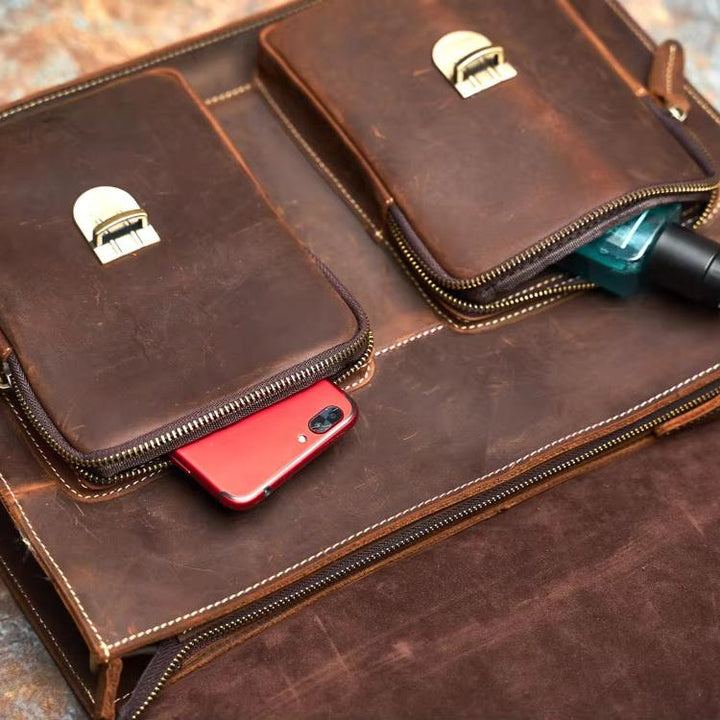 Borsa in pelle marrone con tasche, smartphone rosso e flacone di gel igienizzante. Accessorio elegante e funzionale per lavoro e viaggio.