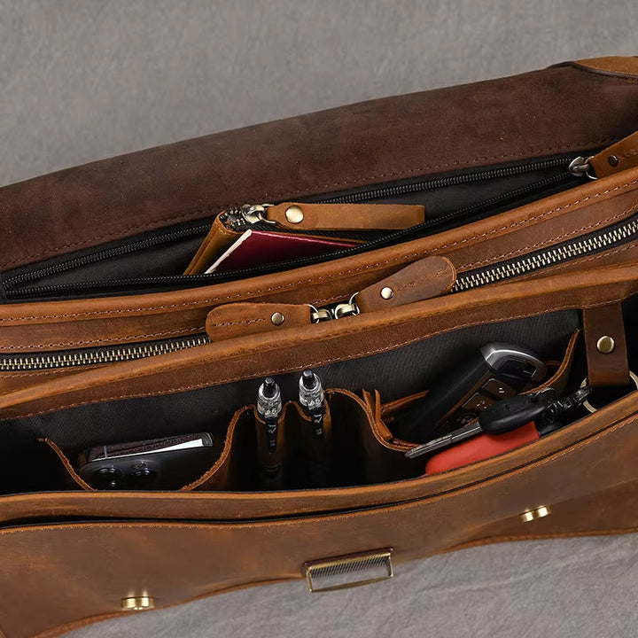 Borsa in pelle marrone aperta, con scomparti organizzati contenenti penne, chiavi e un passaporto. Design elegante e funzionale per viaggi d'affari.