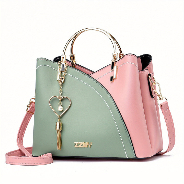 Borsa a tracolla donna in pelle verde e rosa, design elegante con manico dorato e ciondolo a cuore. Accessorio moda femminile chic e versatile.