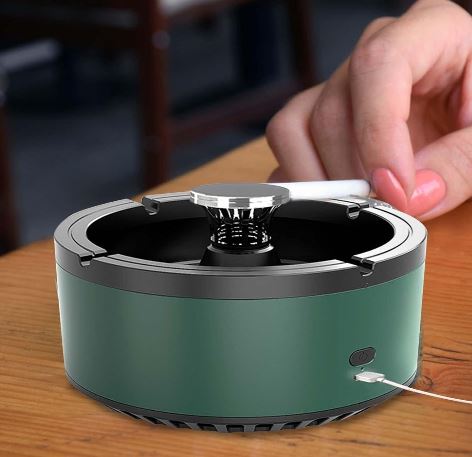 Purificatore d'aria portatile verde su tavolo in legno, con design compatto e moderno, ideale per casa e ufficio. Mano che interagisce con il dispositivo.