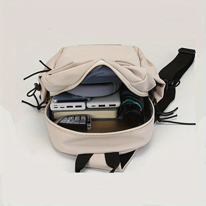 Zaino beige aperto con tasche multiple, contenente dispositivi elettronici e accessori. Design moderno, ideale per viaggi e lavoro.