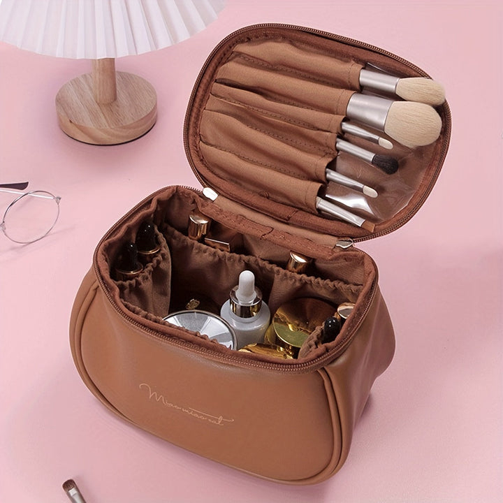 Borsa trucco marrone aperta su tavolo rosa, con pennelli e cosmetici. Elegante organizer da viaggio per make-up. Accessori bellezza essenziali.