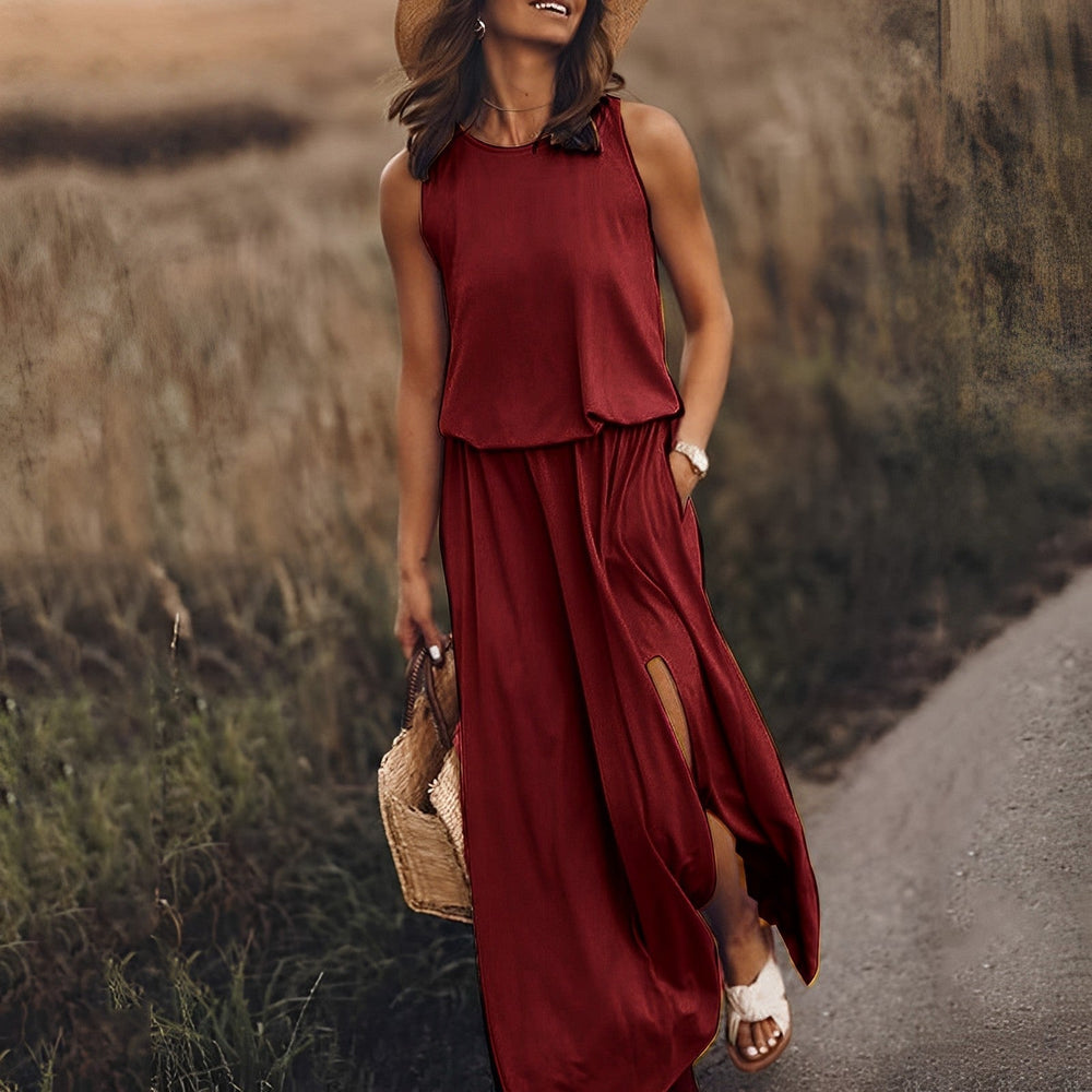 Donna con abito lungo rosso estivo, cappello di paglia e borsa intrecciata, cammina su un sentiero. Moda estiva, abbigliamento casual elegante.