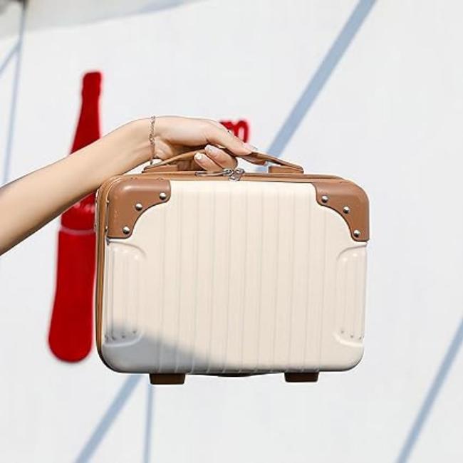 Mano che tiene una valigia vintage beige e marrone, design retrò, ideale per viaggi brevi. Valigia rigida, stile classico, accessorio moda.