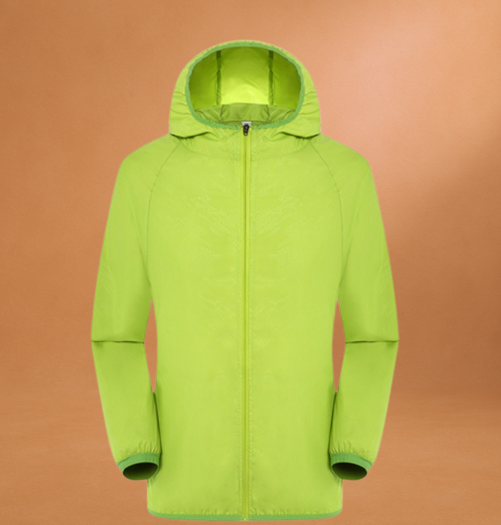 Giacca antivento verde lime con cappuccio, chiusura a zip, sfondo arancione. Abbigliamento outdoor, moda sportiva, impermeabile leggero.