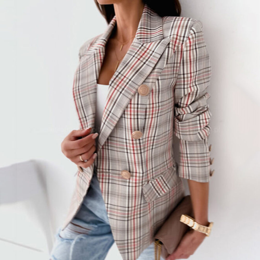 Giacca doppiopetto a quadri beige e rossi, indossata da donna con top bianco e jeans. Elegante moda femminile autunnale.