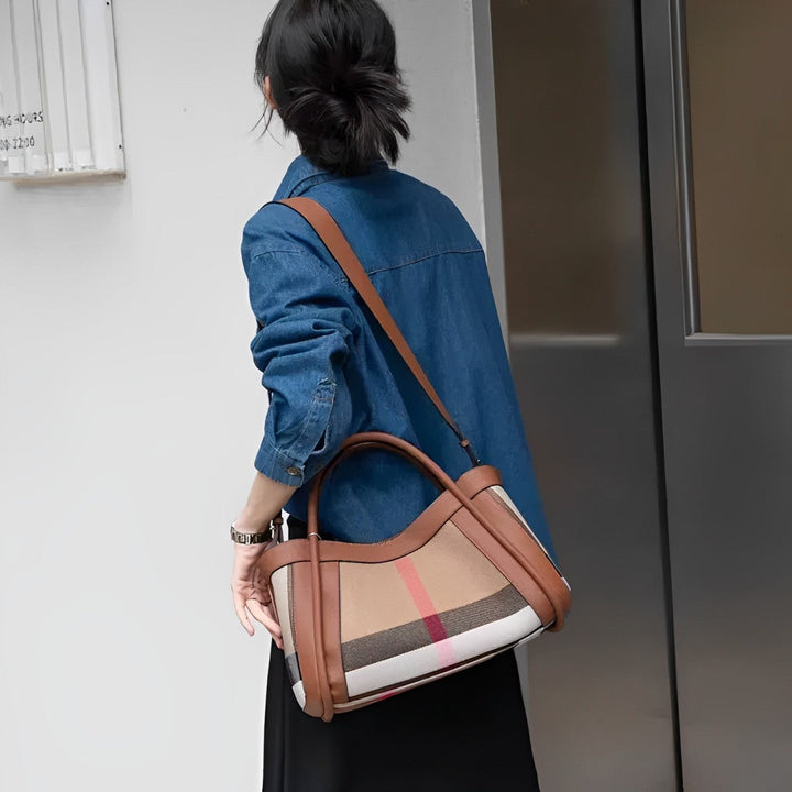 Donna con borsa a tracolla in pelle marrone e tessuto a righe, indossa camicia di jeans. Stile casual chic, moda autunnale, accessori eleganti.