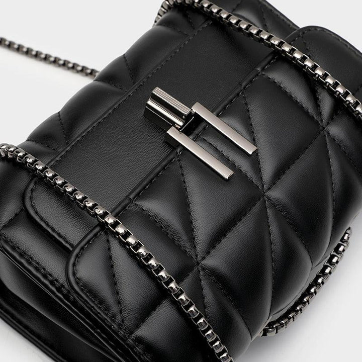 Borsa a tracolla nera trapuntata in pelle con catena metallica e chiusura a gancio. Design elegante e moderno, accessorio moda di tendenza.