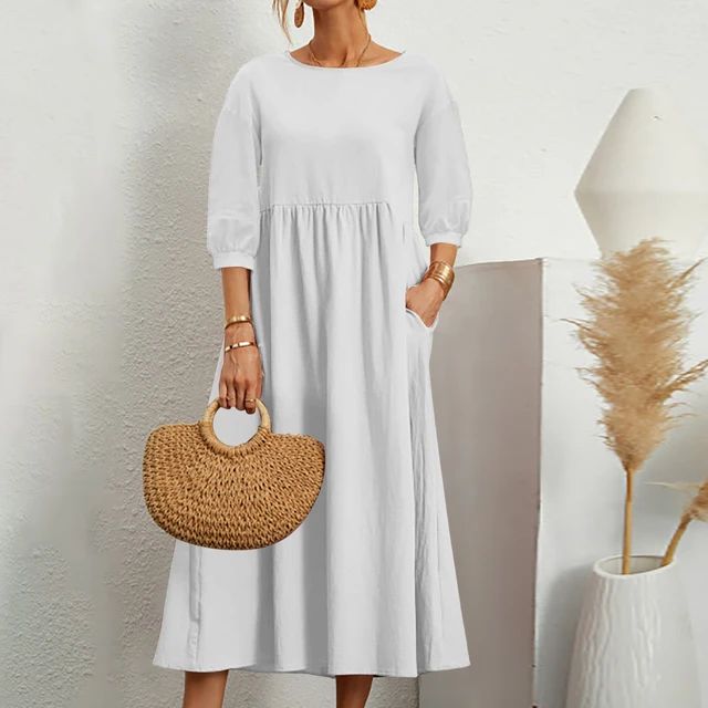 Abito bianco lungo donna con maniche a tre quarti, borsa paglia intrecciata, sfondo minimalista. Moda estiva elegante e casual.