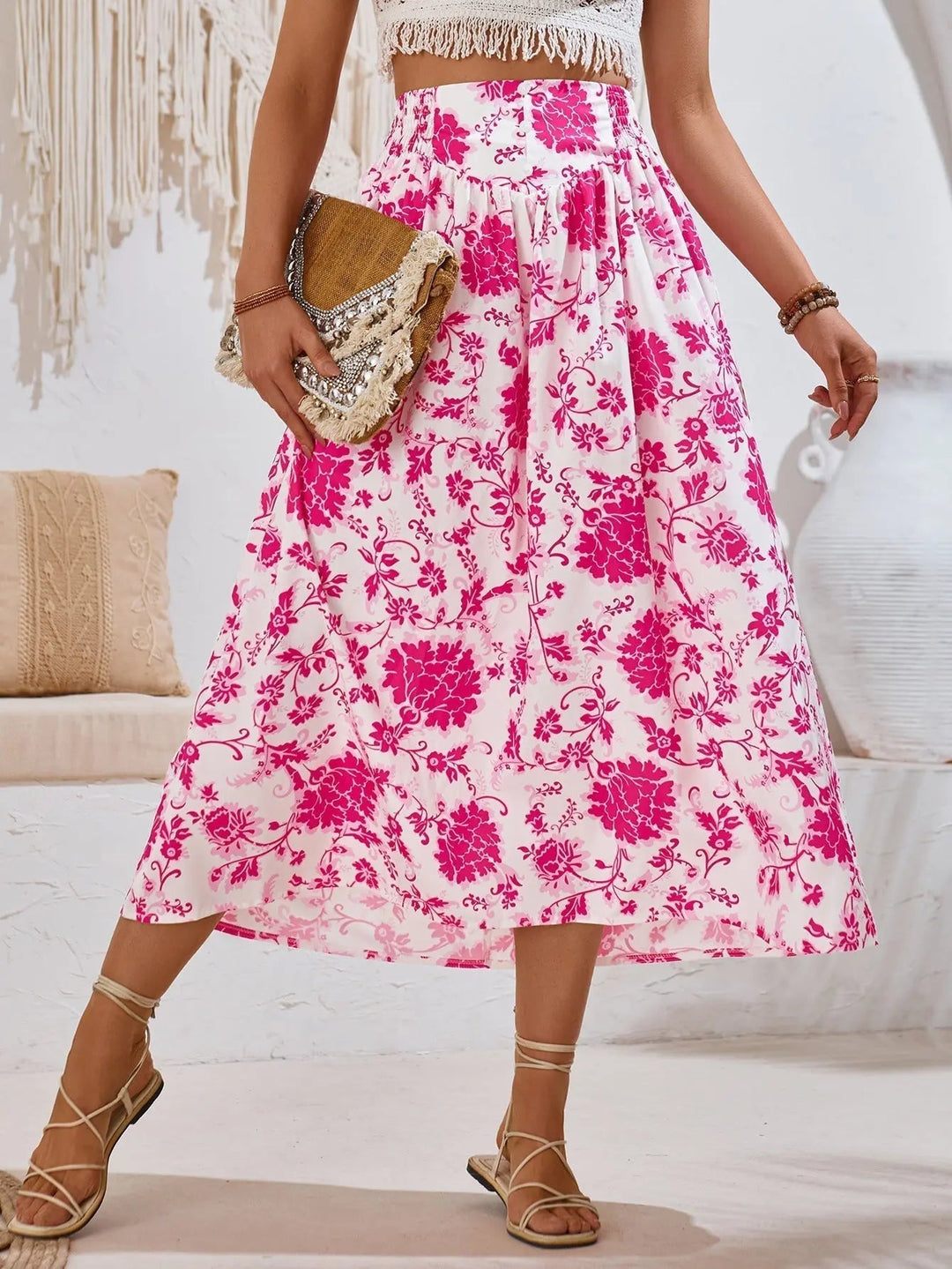 Gonna lunga floreale rosa e bianca, indossata con sandali beige e borsa intrecciata. Moda estiva donna, abbigliamento casual elegante.