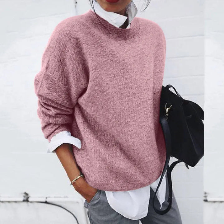 Maglione rosa donna in lana, stile casual, abbinato a camicia bianca e pantaloni grigi. Look autunnale elegante e confortevole.