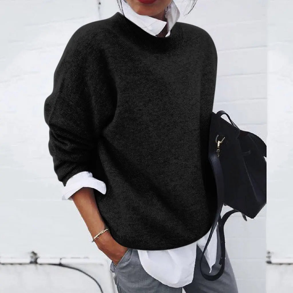 Donna con maglione nero oversize, camicia bianca e borsa nera. Moda casual autunnale, abbigliamento femminile elegante e confortevole.