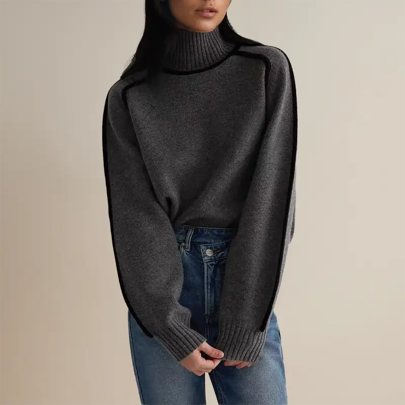Maglione grigio a collo alto da donna, maniche lunghe, abbinato a jeans blu. Moda autunnale, abbigliamento casual elegante.