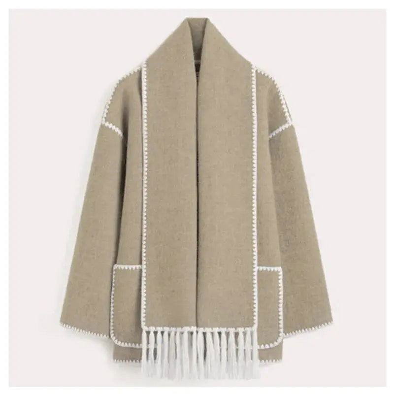 Cappotto beige in lana con frange bianche, dettagli cuciti, tasche frontali. Elegante e caldo, ideale per l'inverno. Moda donna autunno inverno.