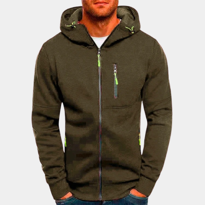 Felpa con cappuccio verde oliva da uomo, zip frontale, tasche con cerniera, dettagli verdi. Abbigliamento casual, moda maschile autunnale.