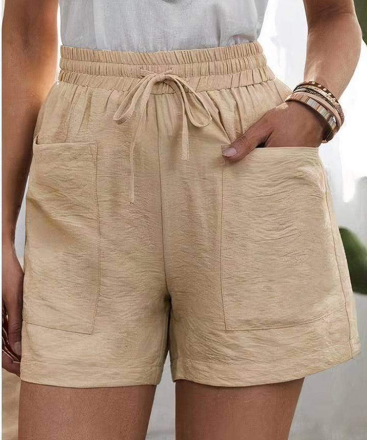 Shorts beige da donna con tasche frontali, elastico in vita e laccio. Design casual estivo, tessuto leggero. Ideale per moda femminile estiva.