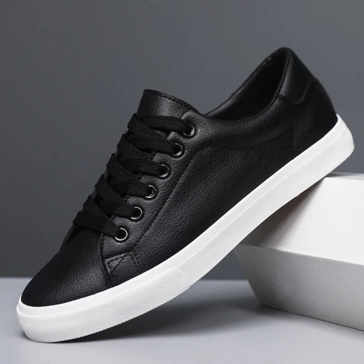 Scarpa da ginnastica nera in pelle sintetica con suola bianca, design casual e moderno, perfetta per uomo, moda urbana, comfort quotidiano.