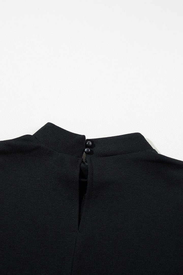 Blusa nera con colletto alto e chiusura a bottone sul retro, elegante e minimalista, perfetta per look formali e casual. Tessuto morbido e confortevole.