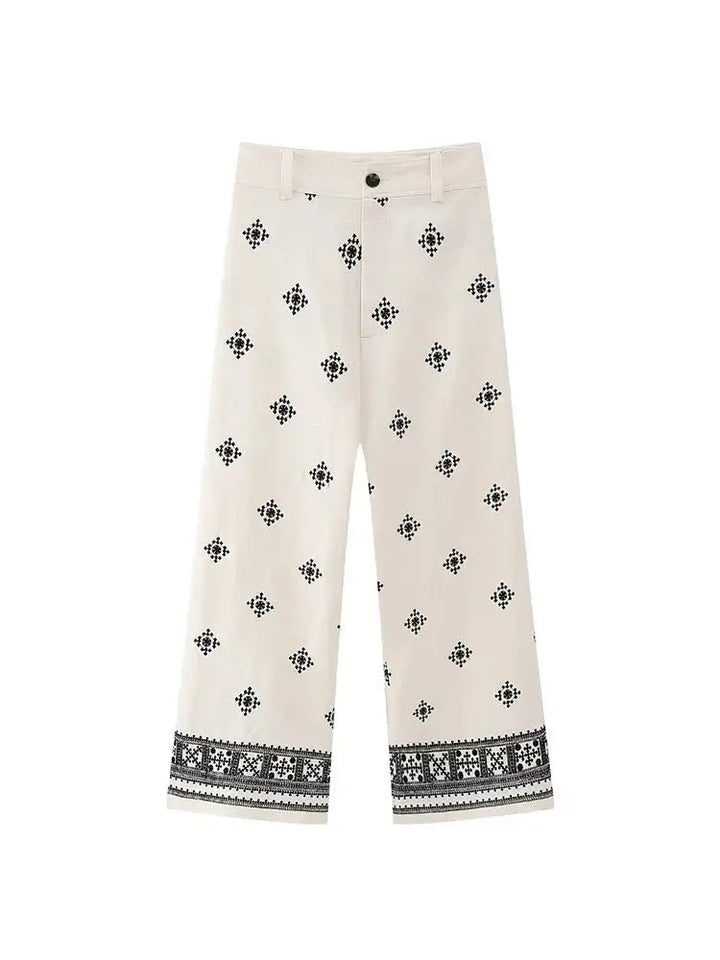 Pantaloni culotte bianchi con motivo geometrico nero, vita media, chiusura a bottone, tessuto leggero. Ideali per moda estiva e casual.