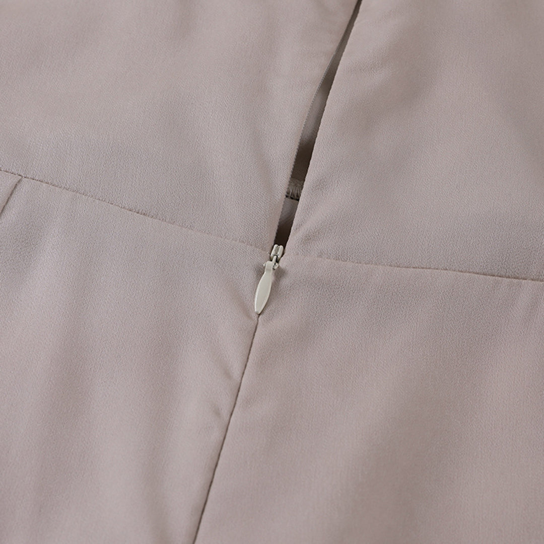 Abito elegante beige con cerniera posteriore, tessuto morbido e cuciture precise. Ideale per occasioni formali e moda donna.