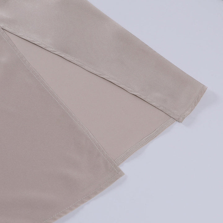 Camicia elegante in raso beige, manica lunga, tessuto lucido, design minimalista. Ideale per moda donna, abbigliamento formale e occasioni speciali.