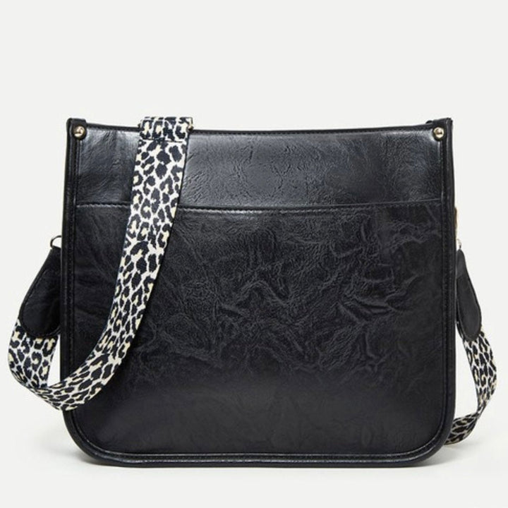 Borsa a tracolla in pelle nera con cinturino leopardato, design elegante e moderno, accessorio moda donna, perfetta per ogni occasione.