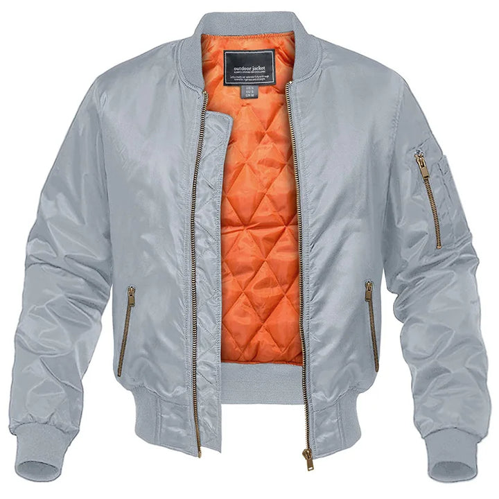 Giacca bomber grigia unisex con fodera arancione trapuntata, zip frontale e tasca sulla manica. Stile casual, moda autunno-inverno.