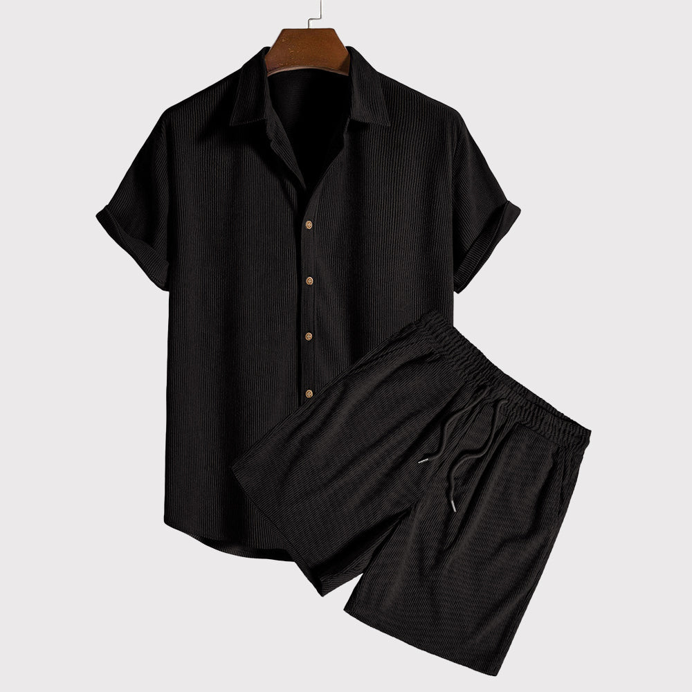 Completo estivo uomo nero, camicia a maniche corte e pantaloncini coordinati, tessuto leggero, ideale per moda casual e look estivo elegante.