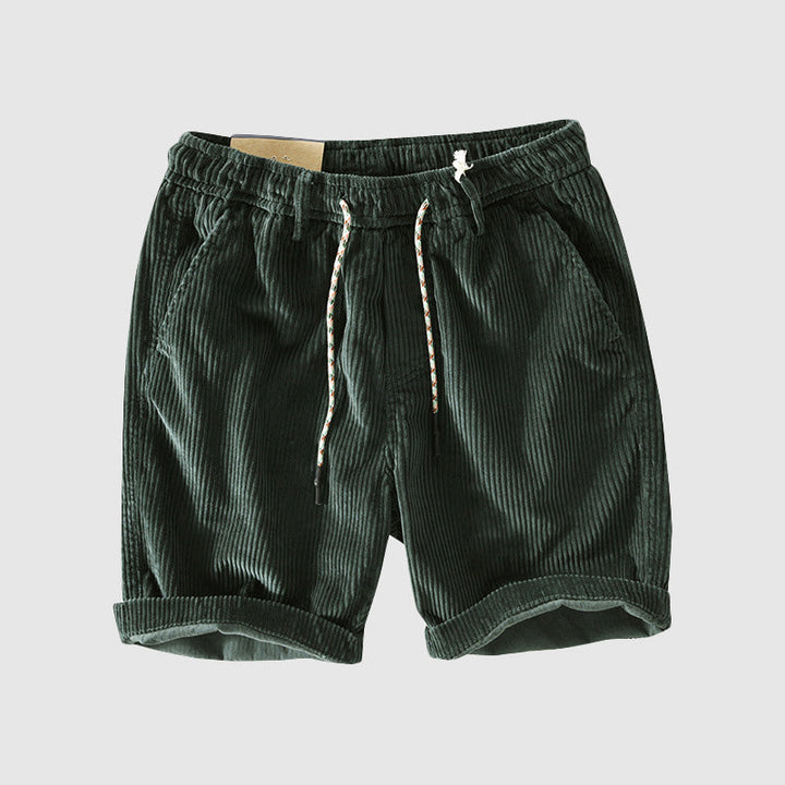 Pantaloncini corti in velluto a coste verde scuro con coulisse, tasche laterali e risvolti. Stile casual estivo per uomo.