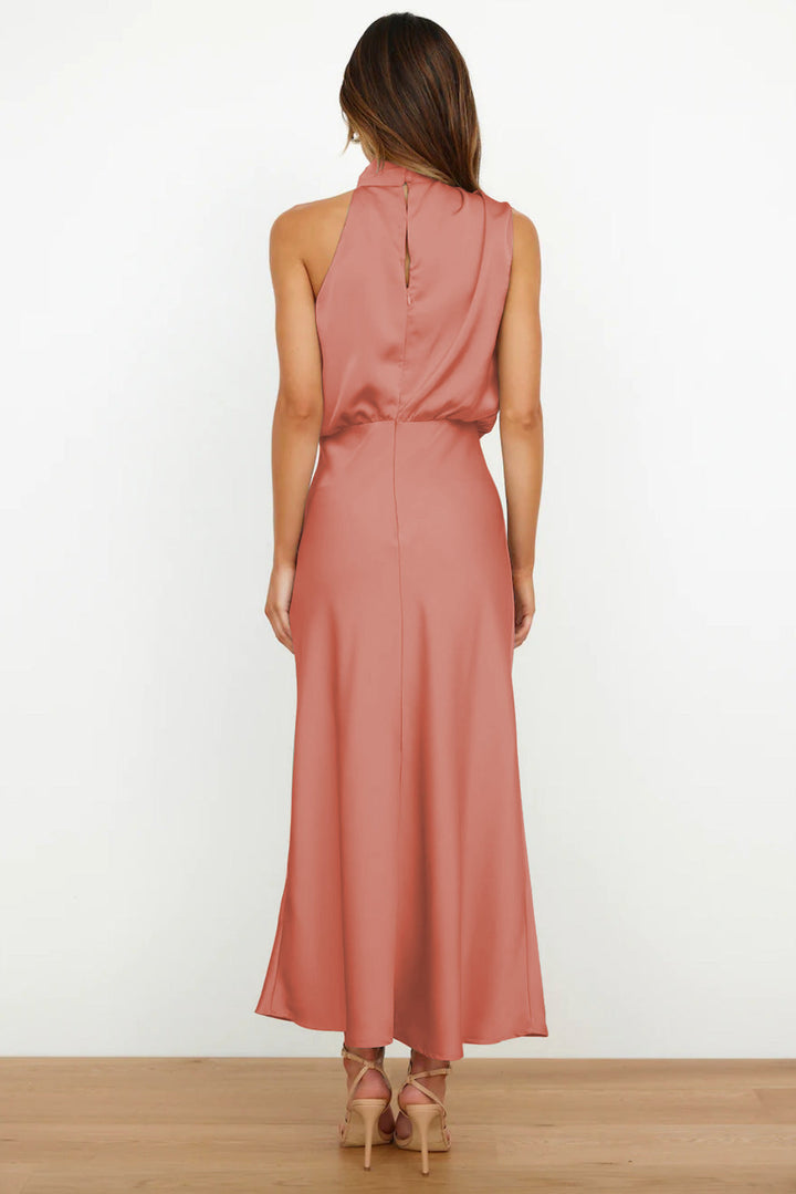 Abito lungo rosa in raso, senza maniche, con scollo alto e schiena scoperta. Elegante e adatto per eventi formali.