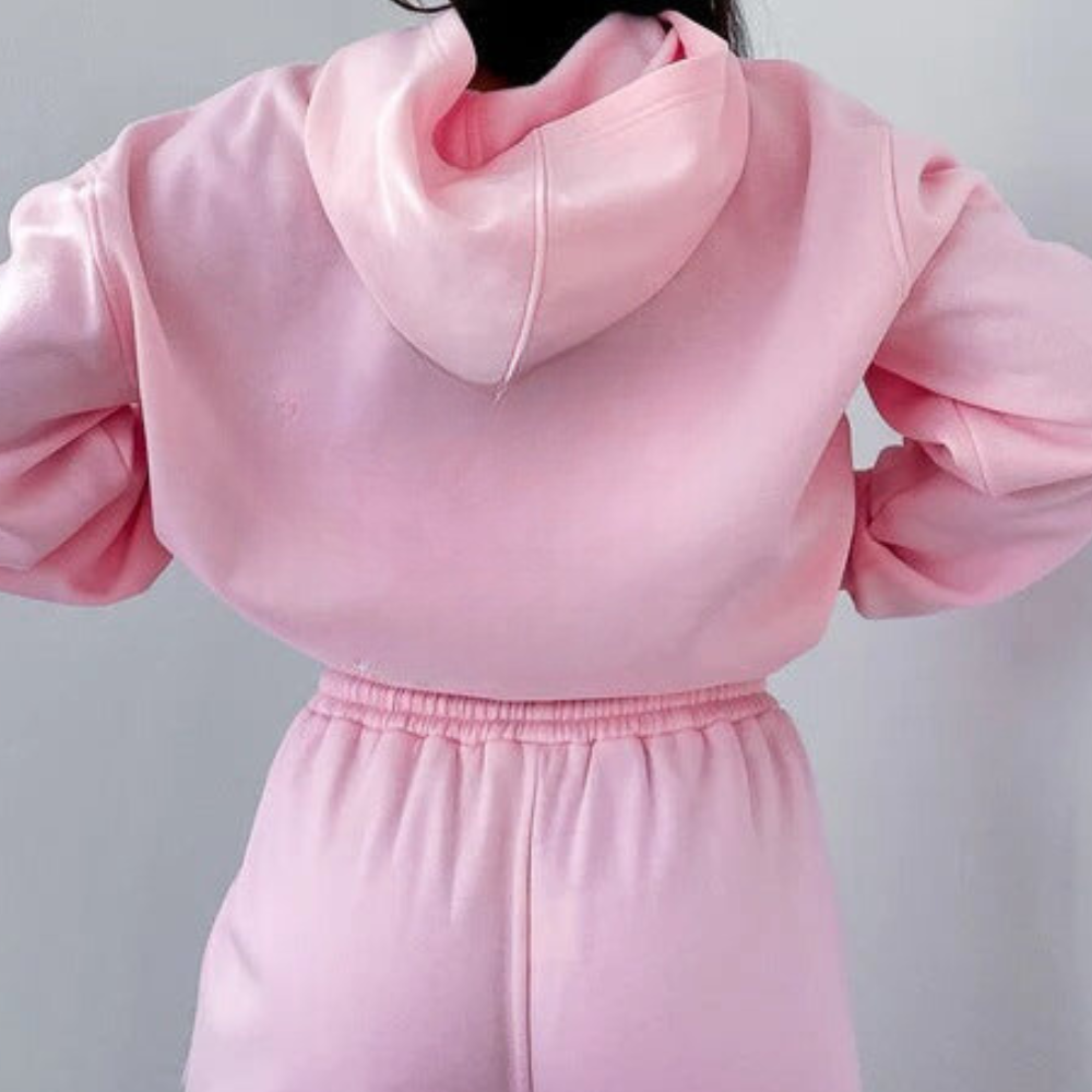 Felpa con cappuccio rosa, abbinata a pantaloni sportivi rosa, moda casual donna, abbigliamento comodo, stile athleisure, tendenza 2023.