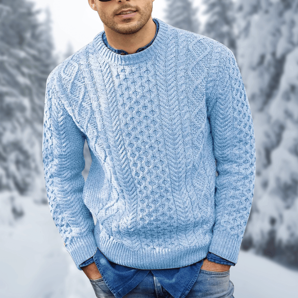Maglione uomo invernale azzurro a maglia intrecciata, indossato su camicia di jeans, sfondo innevato. Moda maschile, abbigliamento caldo.