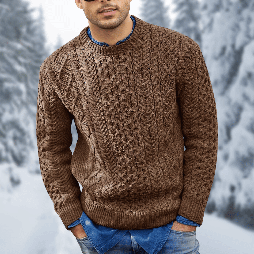 Maglione uomo marrone a maglia intrecciata, indossato su camicia di jeans, sfondo invernale innevato. Moda invernale, abbigliamento casual elegante.