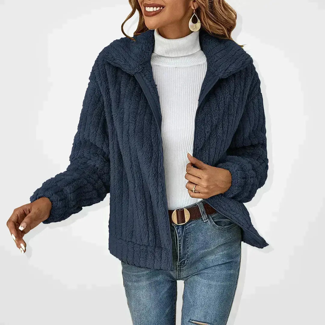 Giacca invernale donna blu scuro, tessuto morbido, abbinata a dolcevita bianco e jeans. Moda casual, abbigliamento caldo, stile autunnale.