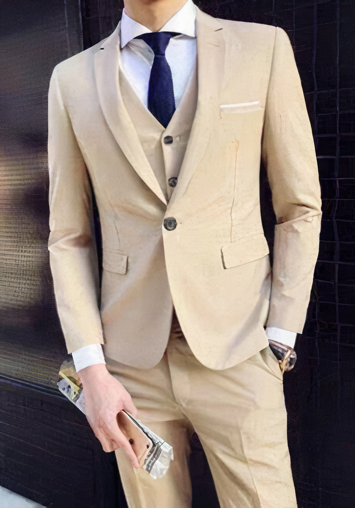 Abito elegante uomo beige, tre pezzi, cravatta blu, camicia bianca, orologio da polso, smartphone in mano. Moda formale maschile.
