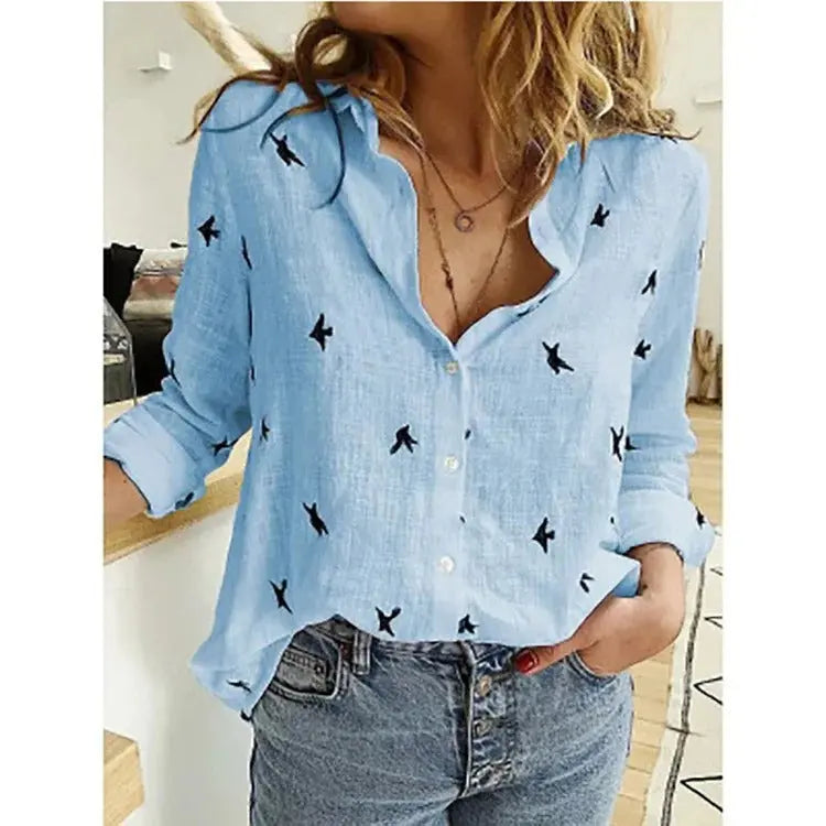 Camicia azzurra donna con stampa uccelli neri, maniche lunghe, abbinata a jeans. Moda casual, stile primaverile, abbigliamento femminile trendy.