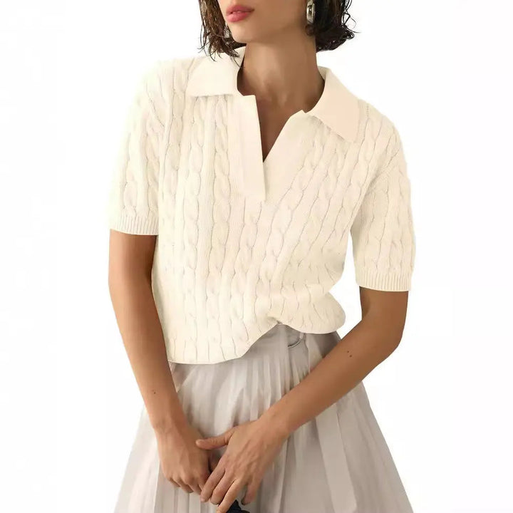 Maglia bianca a trecce con colletto, maniche corte, indossata da donna. Elegante e casual, perfetta per moda femminile estiva.