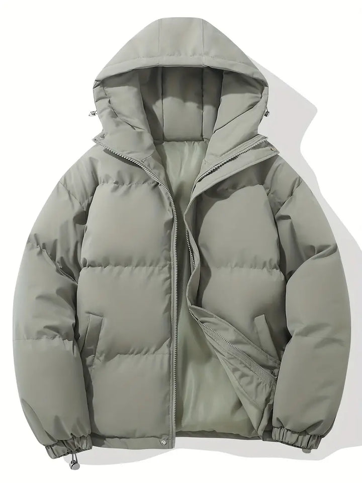 Giacca invernale imbottita grigia con cappuccio, design trapuntato, chiusura a zip, ideale per climi freddi. Moda uomo, abbigliamento outdoor.