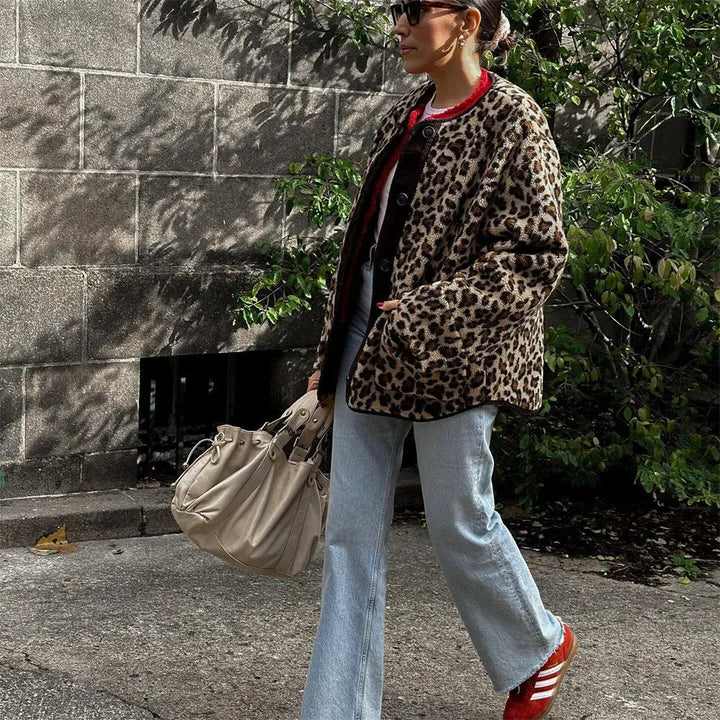 Donna con cappotto leopardato, jeans a zampa, borsa beige e scarpe rosse. Moda autunnale, stile urbano, tendenze abbigliamento donna.