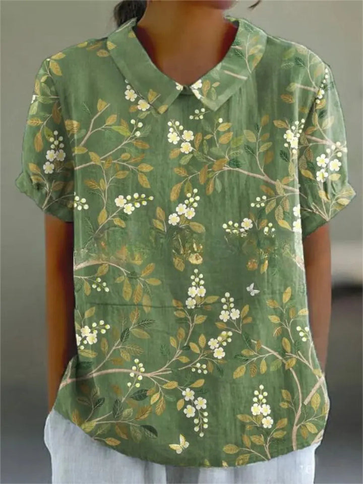 Camicia verde donna con stampa floreale, maniche corte, colletto classico. Moda estiva casual, tessuto leggero, stile vintage elegante.