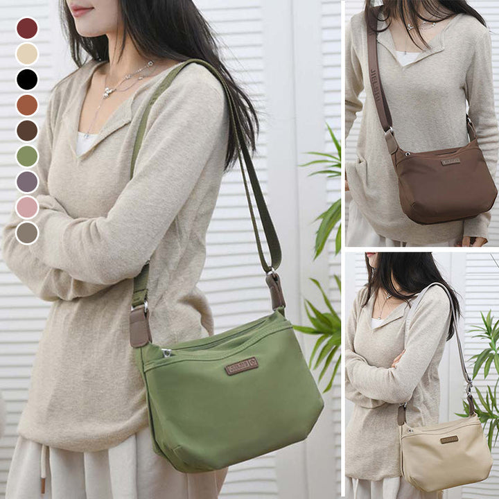 Donna con borsa a tracolla in tessuto verde, marrone e beige. Design casual, ideale per moda quotidiana. Disponibile in vari colori.