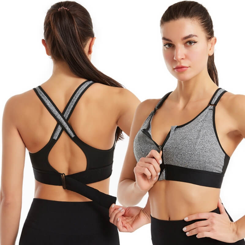 Donna in reggiseno sportivo grigio e nero con chiusura frontale, design incrociato sulla schiena. Abbigliamento fitness, comfort, supporto.