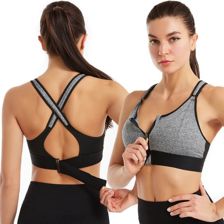 Donna in reggiseno sportivo grigio e nero con chiusura frontale, design incrociato sulla schiena. Abbigliamento fitness, comfort, supporto.