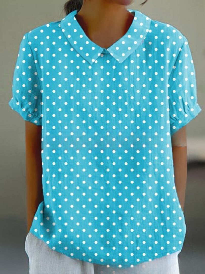 Blusa azzurra a pois bianchi, maniche corte, colletto classico. Moda donna, casual, estiva, tessuto leggero. Ideale per look quotidiani.