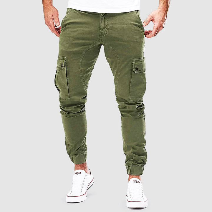 Pantaloni cargo uomo verde militare, tasche laterali, vestibilità slim, stile casual, abbigliamento maschile, moda urbana, scarpe bianche.