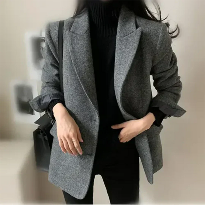 Giacca donna elegante grigia, stile casual chic, abbinata a maglione nero. Moda autunnale, outfit versatile per ufficio o uscite informali.