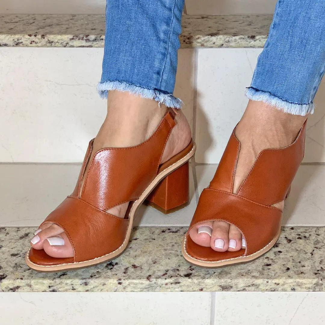 Sandali donna in pelle marrone con tacco largo, design aperto, indossati con jeans. Scarpe estive eleganti, moda femminile, calzature comode.