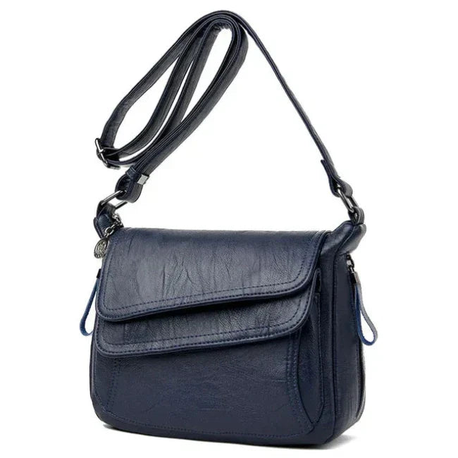 Borsa a tracolla in pelle blu scuro, design elegante e moderno, con chiusura a patta e cerniera. Accessorio moda donna, versatile e di tendenza.