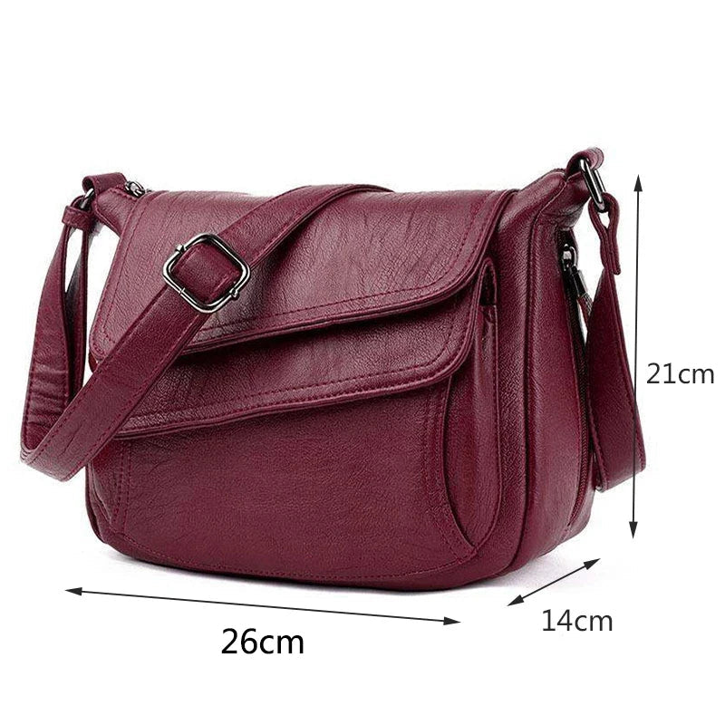 Borsa a tracolla in pelle rossa, dimensioni 26x14x21 cm, con chiusura a patta e cinturino regolabile. Elegante e pratica per uso quotidiano.